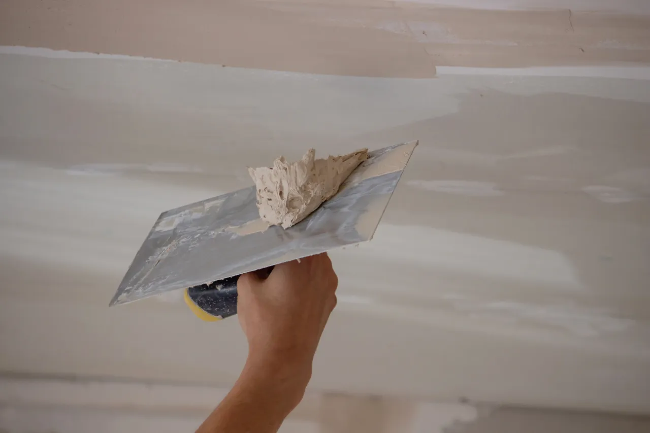 Ceiling drywall repair with a hand trowel in New York