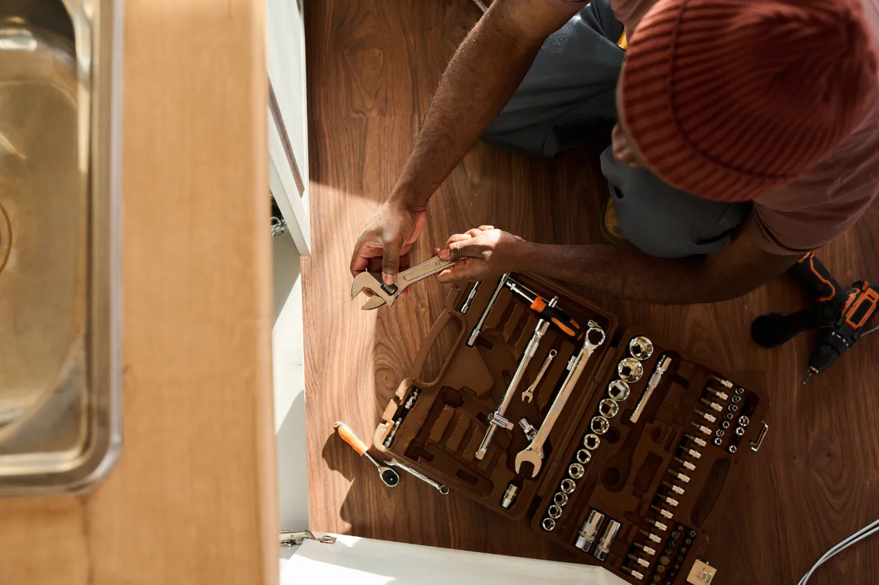 Under-sink plumbing maintenance in a New York rental unit